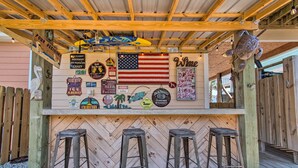Eine Holztresen-Ecke mit einer rustikalen amerikanischen Flagge, verschiedenen Schildern und drei Barhocker.