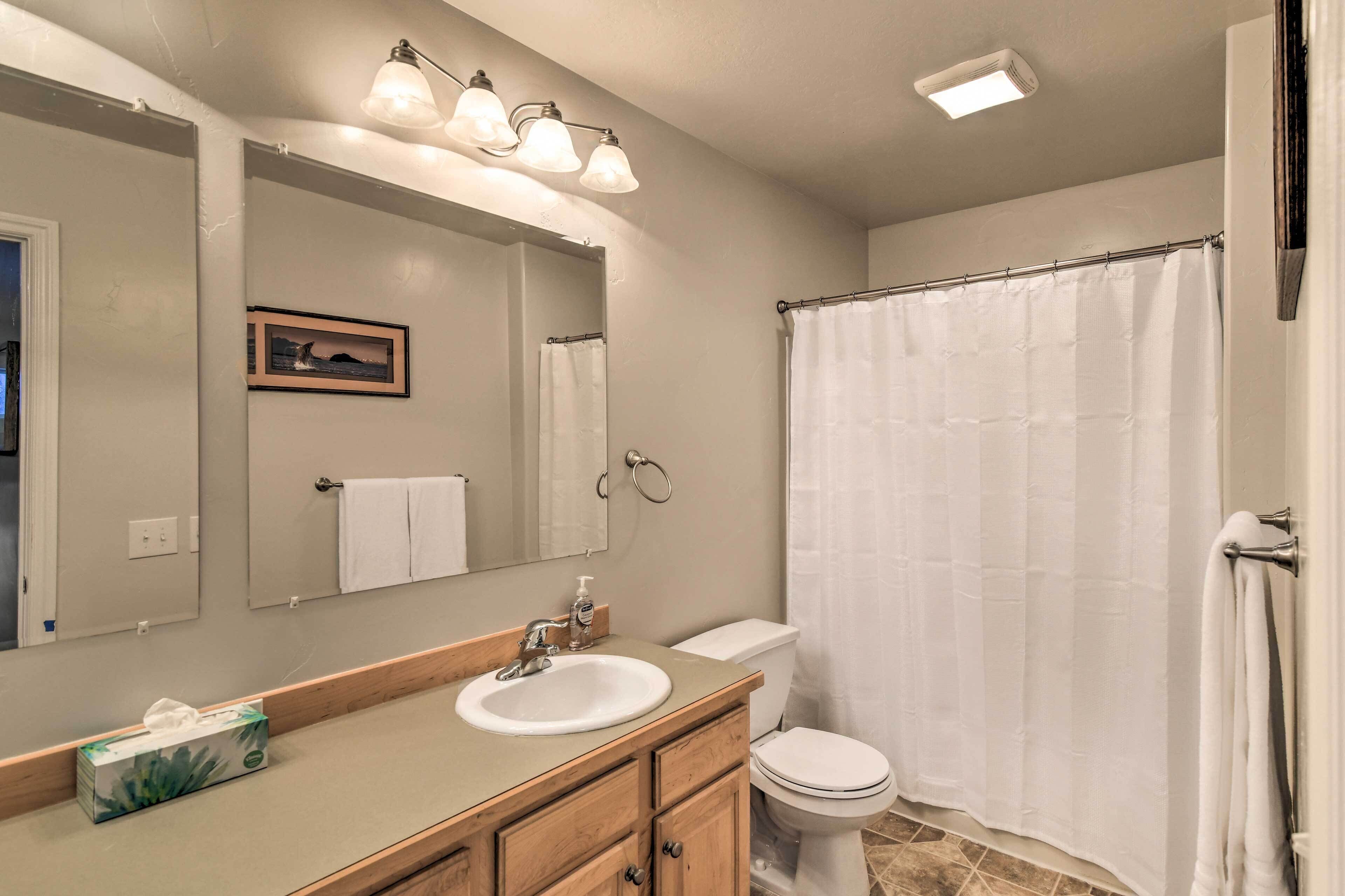 A bathroom with a sink, mirror, and toilet.