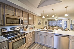 A modern kitchen with stainless steel appliances, wooden cabinets, and pendant lighting. - 4 Mi to Strip: Cozy Lake-view Retreat in Branson (Branson)