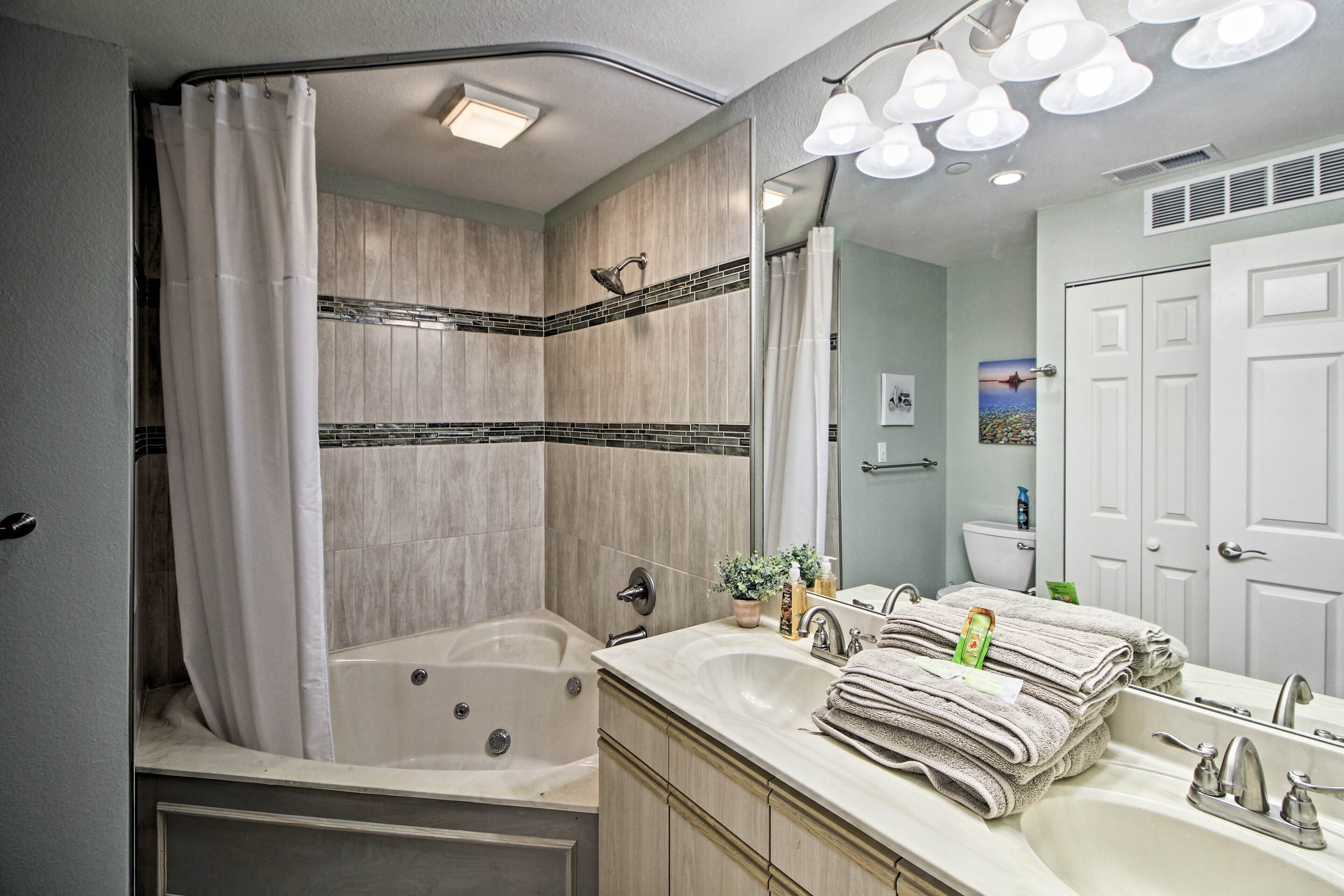 A modern bathroom with a bathtub, a vanity with a sink, and a shower area.