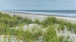 A beach with sand dunes and a white structure in the distance. - Brigantine Beach Retreat: Swim, Fish, & Shop! (Brigantine)