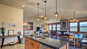 A spacious kitchen with a large island, wooden cabinets, and pendant lighting. - Winter Park Retreat: Mtn Views & Pool Access! (Fraser)