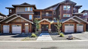 A multi-story residential building with a central entrance, multiple garage doors, and a landscaped front yard. - Winter Park Retreat: Mtn Views & Pool Access! (Fraser)