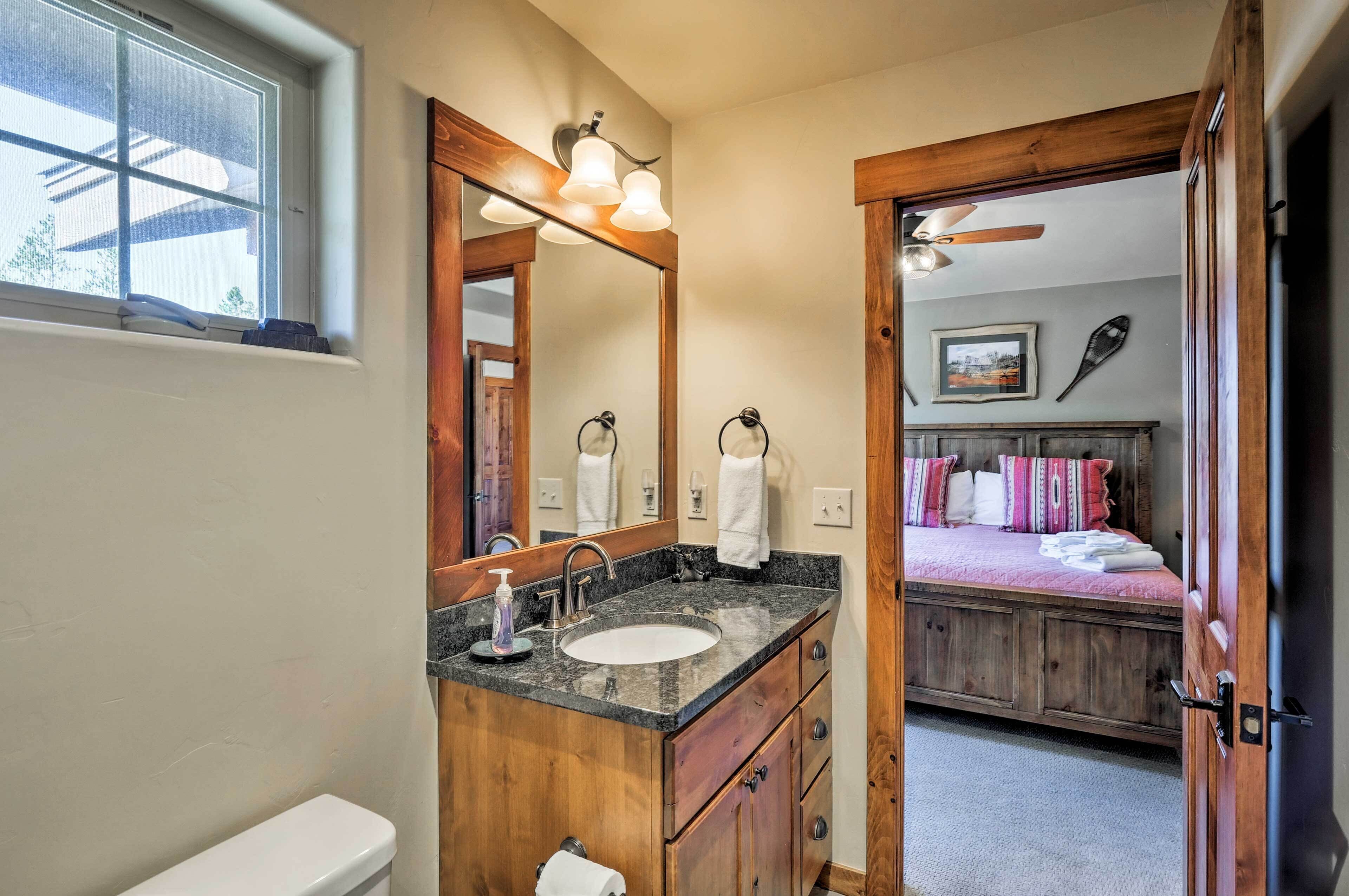 Une salle de bain avec un meuble-lavabo en bois, un évier et un grand miroir.