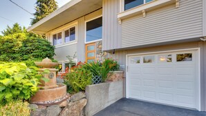 Une maison à deux étages avec un garage, une fontaine en pierre et un jardin bien entretenu.