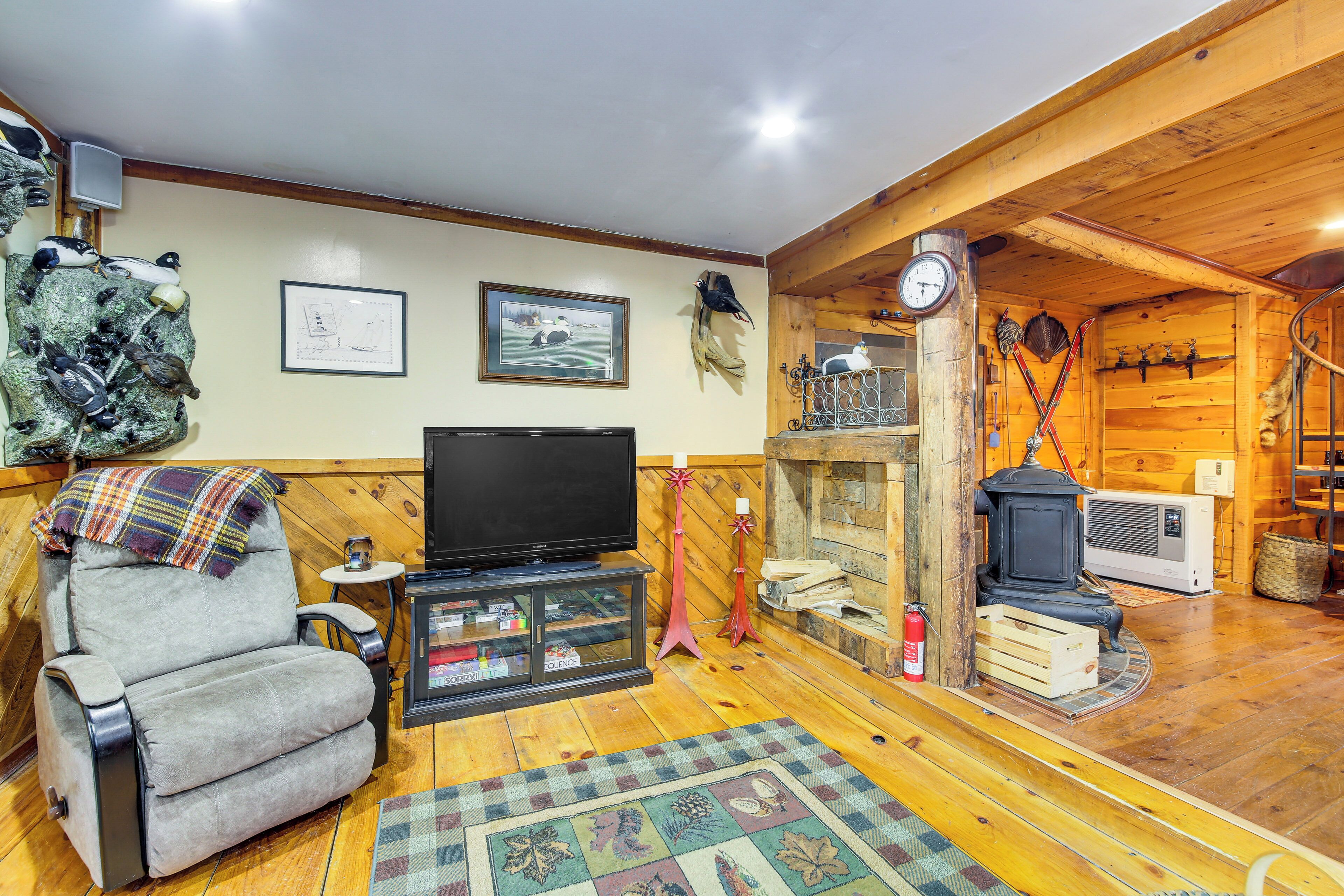 Una sala de estar acogedora con chimenea, un sillón cómodo, un televisor y detalles de madera.