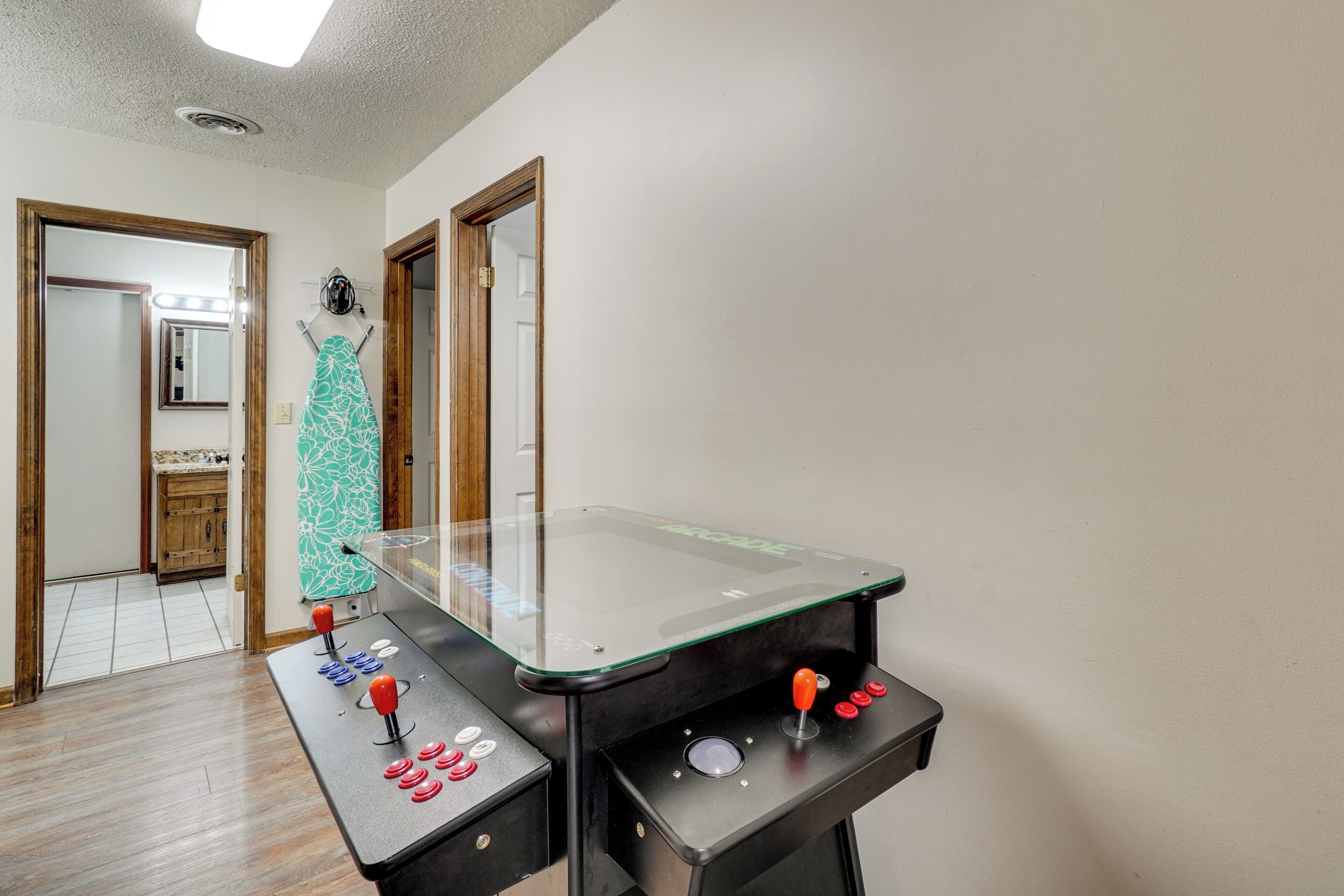 A room with a foosball table, a mirror, and a door leading to another room.