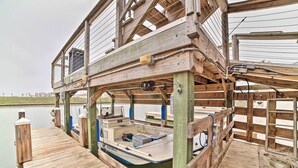 Une jetée en bois avec un bateau amarré en dessous d’une structure en bois dotée de garde-corps.