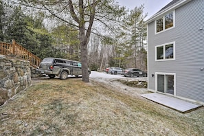 A two-story building with a covered porch and a stone retaining wall. - Cozy Ski-in/ski-out Condo on Magic Mountain (Londonderry)