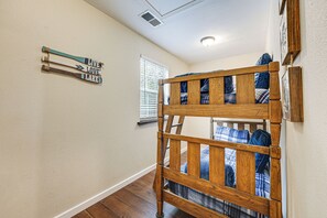 A bunk bed with a wooden frame and plaid bedding, a wall-mounted sign with the words "LIVE LOVE LAKE," and a window with blinds. - Lakeside Blue Eye Escape w/ Game Room & Hot Tub! (Blue Eye)