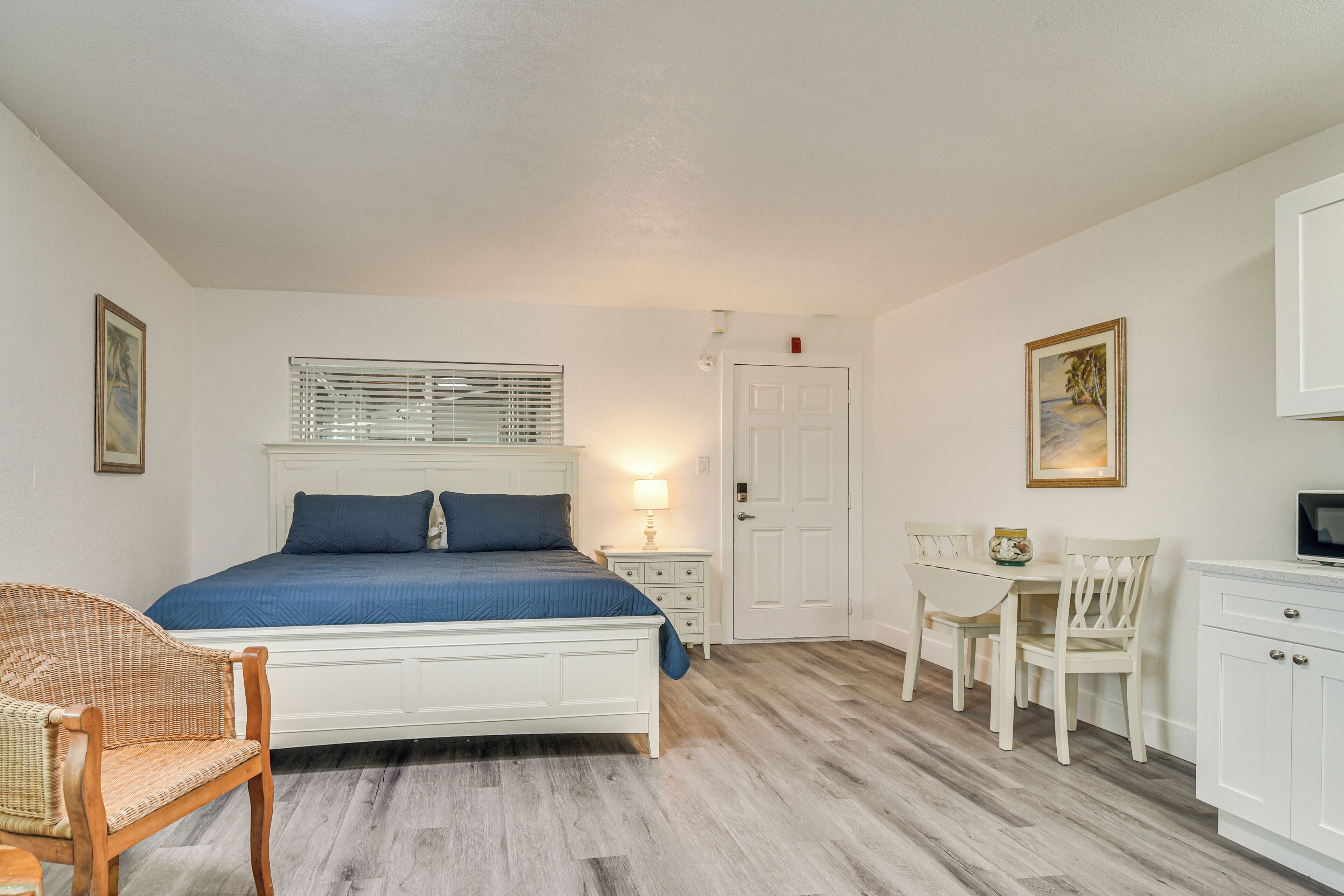 A bedroom with a bed, a chair, a desk, and a television.