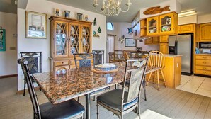 Eine geräumige Küche mit Granit-Arbeitsplatten, Holzschränken und einem Edelstahl-Kühlschrank.