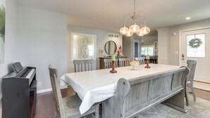 A dining area with a large table, chairs, a piano, and a chandelier. - Dock, Hot Tub! Family-friendly Camdenton Haven (Camdenton)
