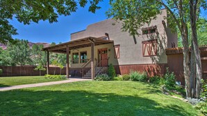 A house with a covered porch, a front door, and a small front yard with a lawn and a tree. - Moab Getaway w/ Ample Parking, Walk to Main Street (Moab)