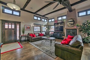 A spacious living room with a fireplace, a ceiling fan, and a large mirror. - Moab Getaway w/ Ample Parking, Walk to Main Street (Moab)