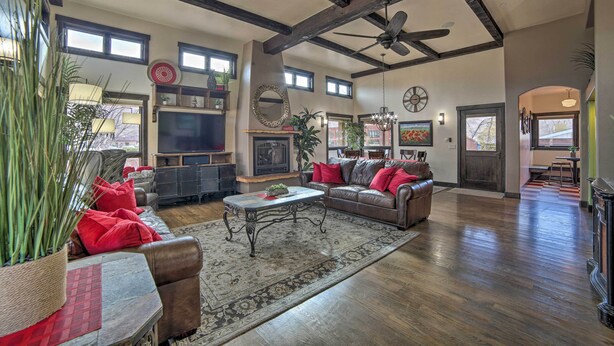A spacious living room with a fireplace, leather sofa, and a large television. - Moab Getaway w/ Ample Parking, Walk to Main Street (Moab)
