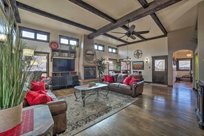 A spacious living room with a fireplace, leather sofa, and a large television. - Moab Getaway w/ Ample Parking, Walk to Main Street (Moab)