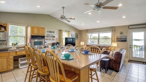 A spacious kitchen with wooden cabinets, a dining table set for six, and two ceiling fans. - Rutledge Hilltop Home on Cherokee Lake w/ Decks! (Rutledge)