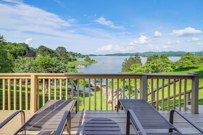Una terraza de madera con vistas a un lago y follaje circundante.