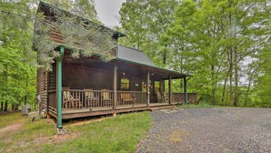 Eine Holzhütte mit Veranda, umgeben von Bäumen.