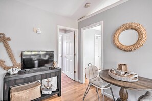 A hallway with a dark console table, a television, and a wicker basket labeled "beach". - Bright Belmar Cottage < Half Mi to Boardwalk! (Belmar)
