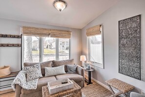 A cozy living room with a sofa, a coffee table, and a cat tree. - Bright Belmar Cottage < Half Mi to Boardwalk! (Belmar)