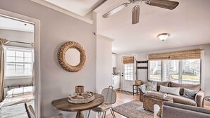 A spacious living room with a wooden dining table, a comfortable sofa, and a large mirror on the wall. - Bright Belmar Cottage < Half Mi to Boardwalk! (Belmar)