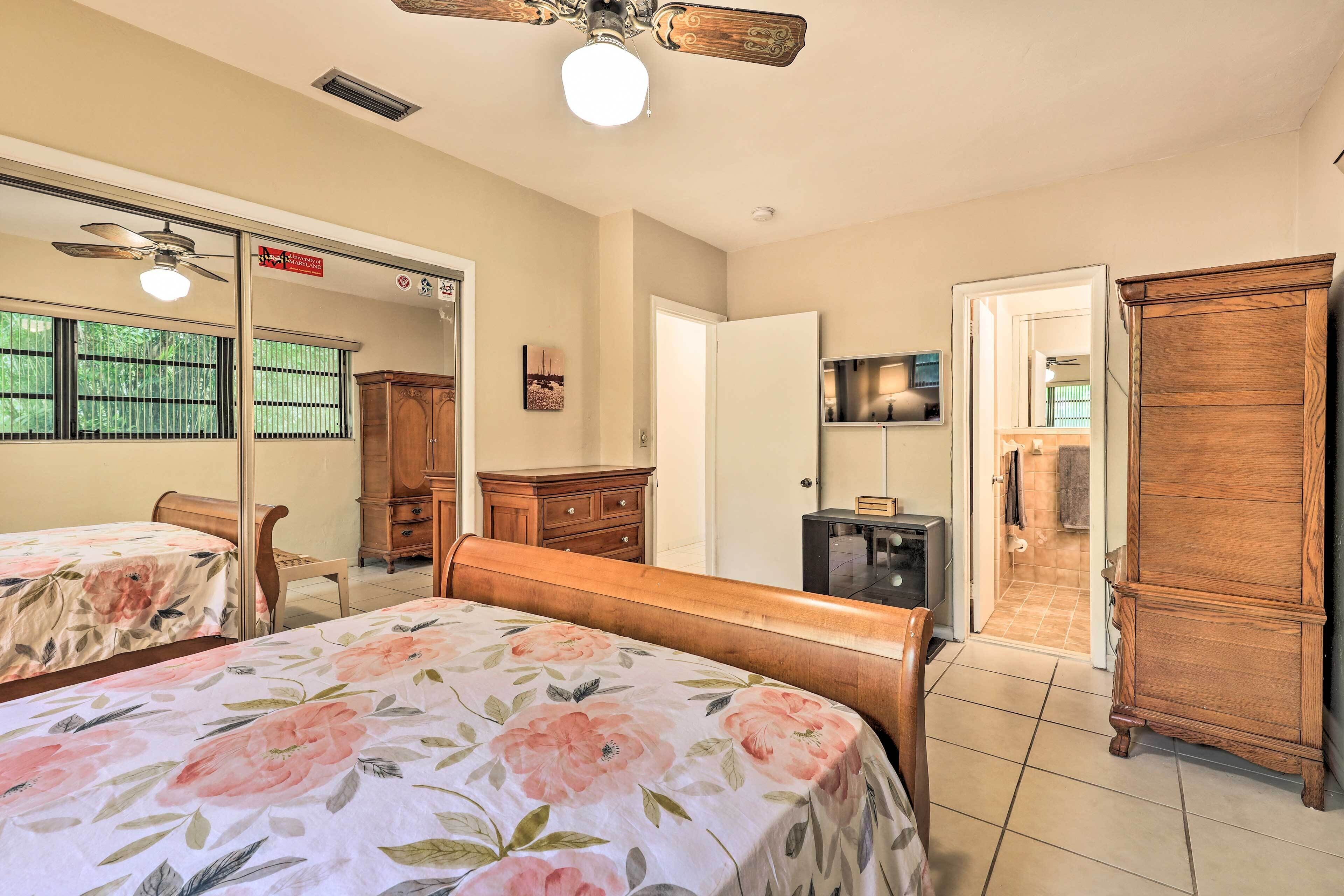 A bedroom with a bed, wooden wardrobe, and a television.