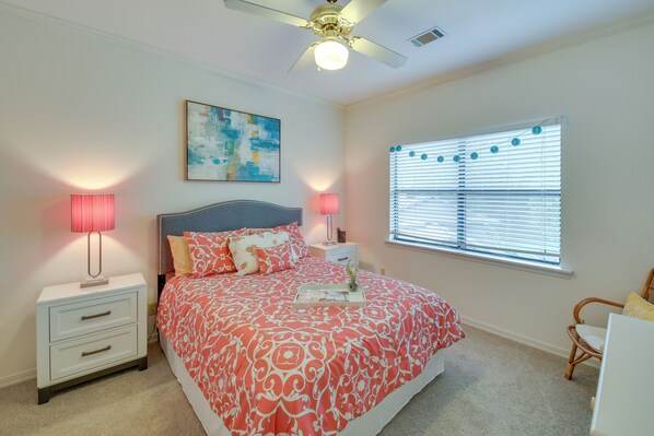 A bedroom with a bed, nightstands, a ceiling fan, a window with blinds, and a painting on the wall. - Lake-view Balcony: Hot Springs Penthouse! (Hot Springs)