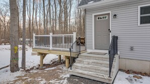 A house with a front deck, a front door, and a small porch area. - Hike & Ski: Pocono Lake Home w/ Community Perks! (Pocono Lake)