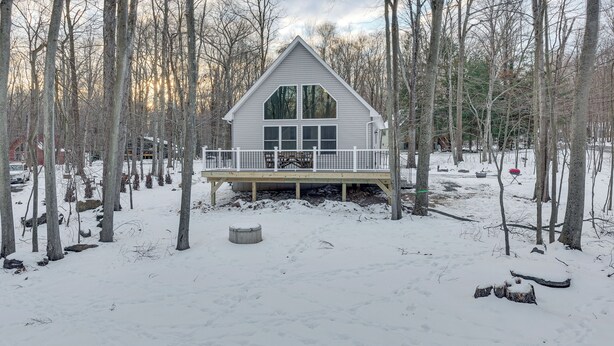 A cabin with a deck, surrounded by trees and snow. - Hike & Ski: Pocono Lake Home w/ Community Perks! (Pocono Lake)