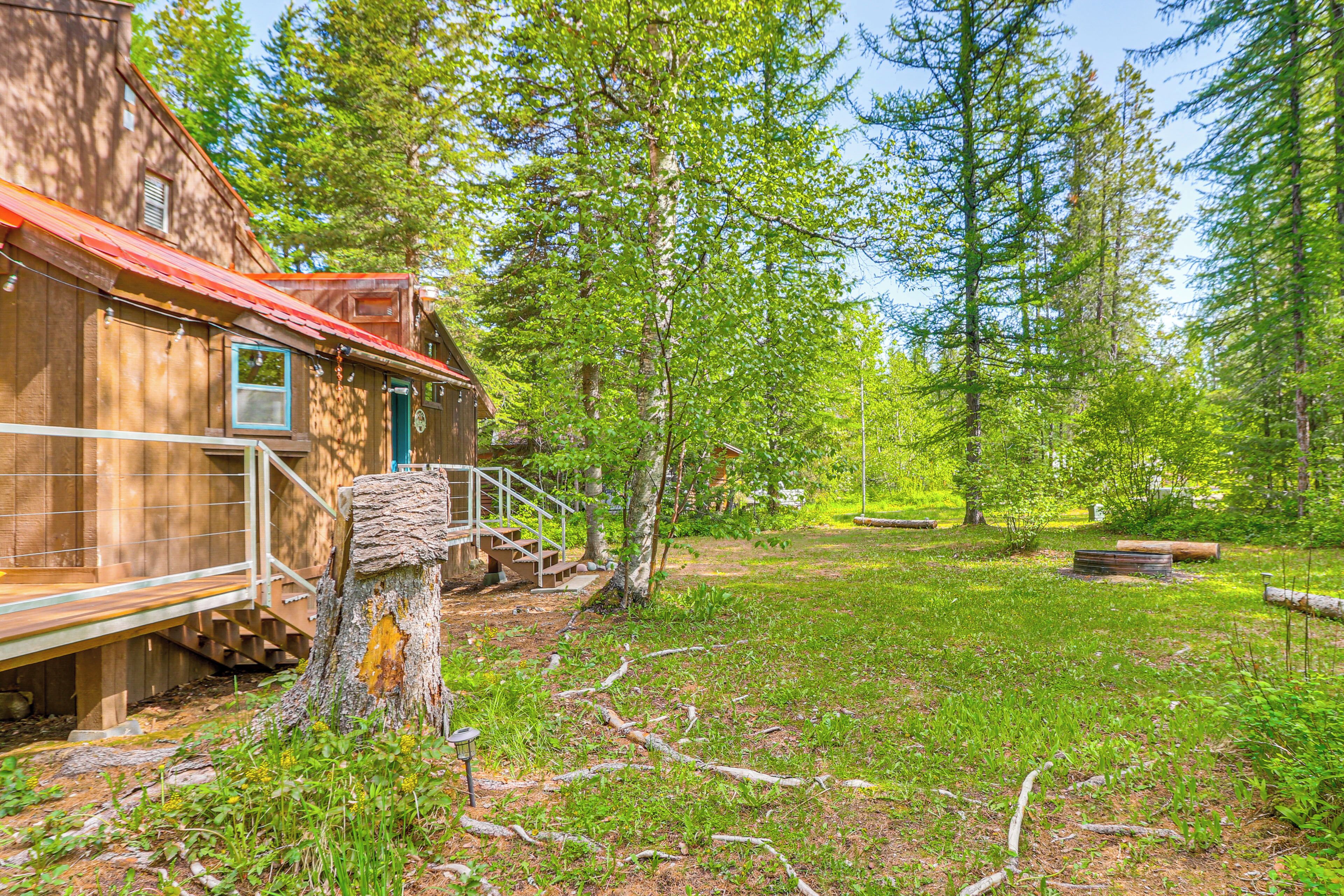 A rustic cabin with a wooden exterior, a porch, and a staircase leading to a deck.