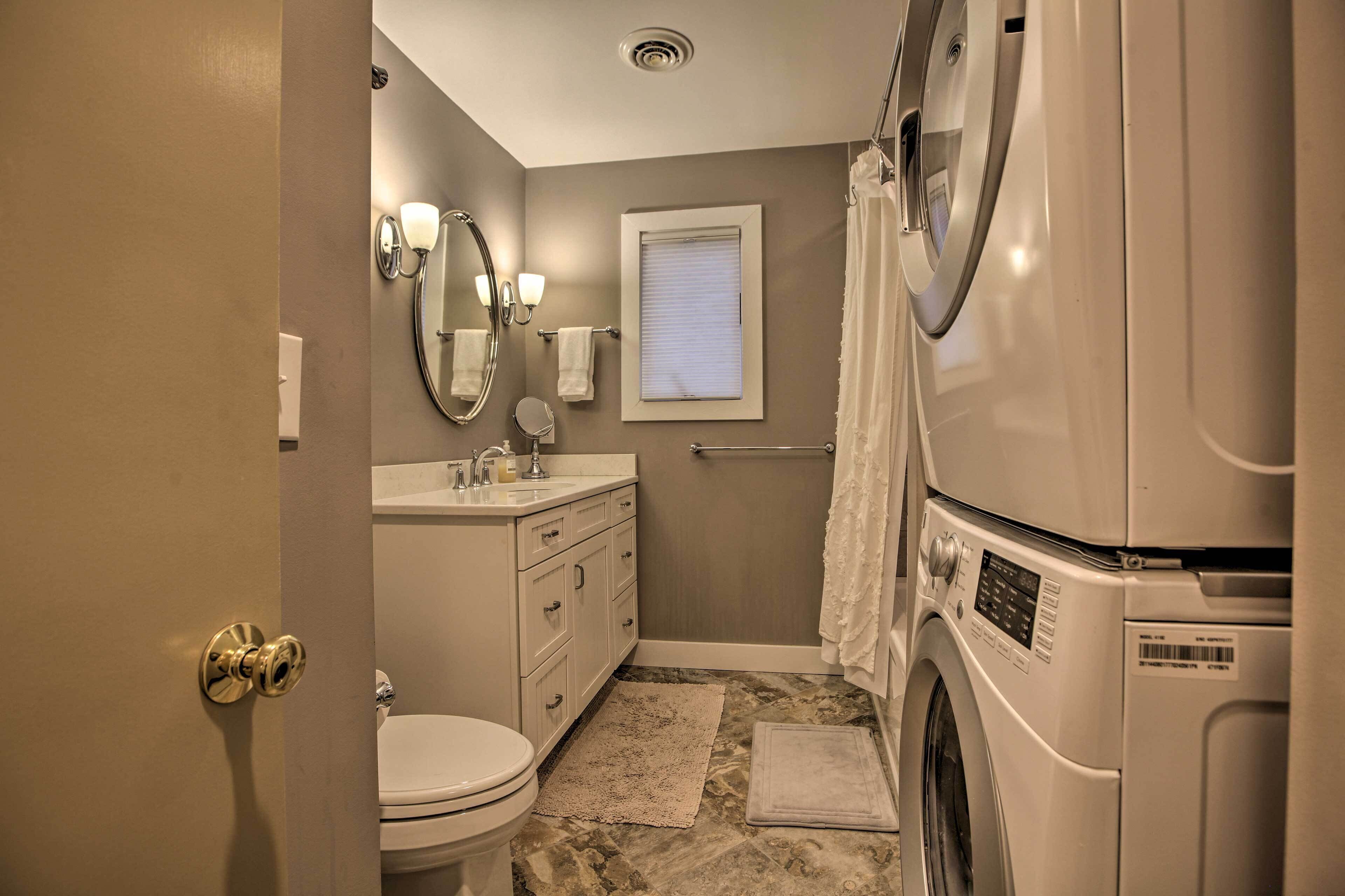 Une petite salle de bain comprenant des toilettes, un lavabo, un miroir et un lave-linge.