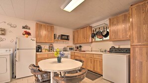 A kitchen with wooden cabinets, a white refrigerator, a microwave, and a stove.