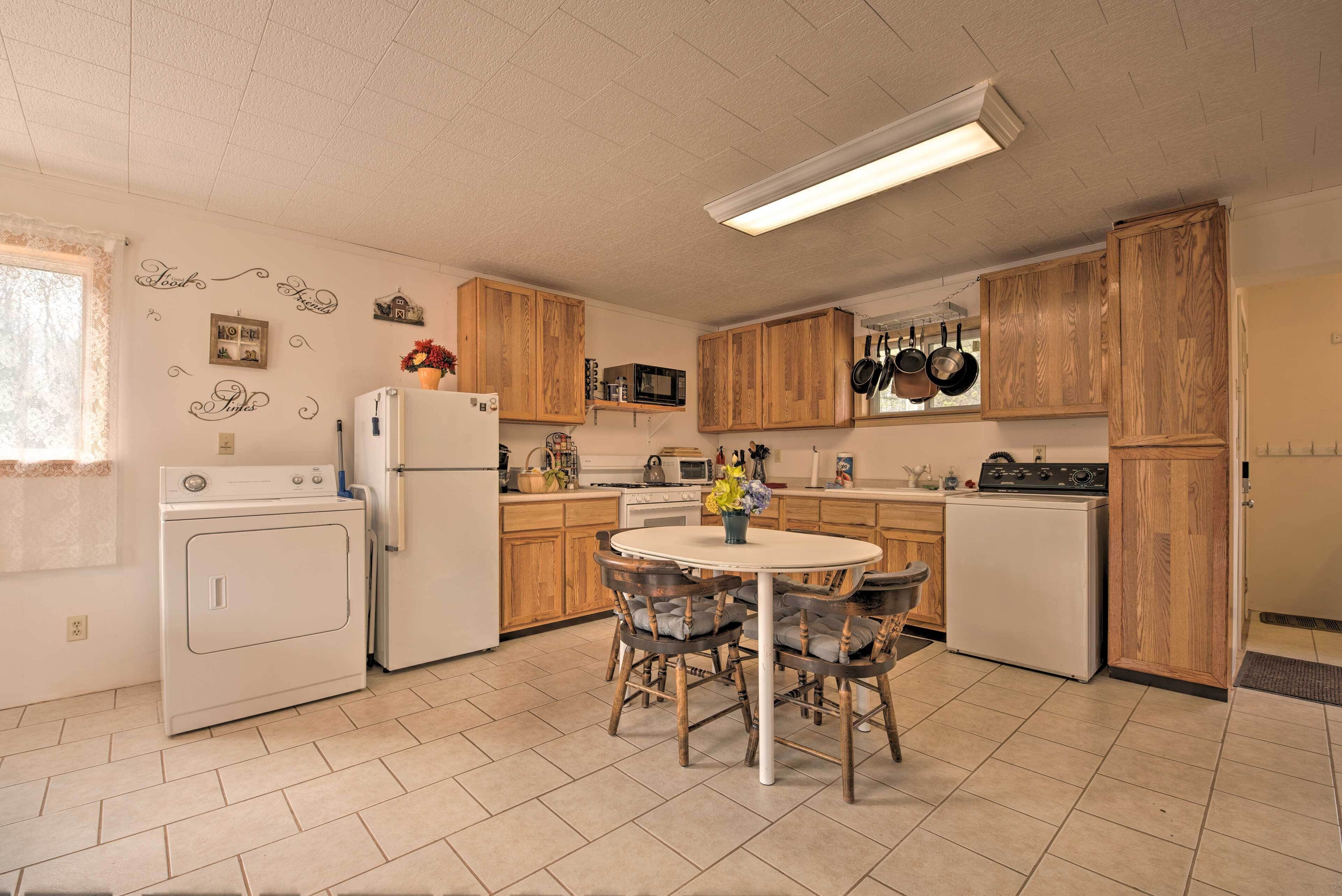 A compact kitchen with wooden cabinets, a central island, and a washing machine.