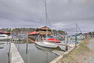Un puerto deportivo con barcos amarrados, un muelle de madera y un edificio con techo rojo.