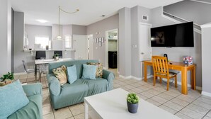 A modern living room with a sofa, coffee table, and a TV mounted on the wall. - Kissimmee Escape ~ 10 Mi to Disney World! (Kissimmee)