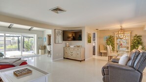 A spacious living area with a modern kitchen, a dining area, and a comfortable seating area with a sofa and chairs. - Canalfront Home w/ Dock & Pool: 5 Mi to Ft Myers! (North Fort Myers)
