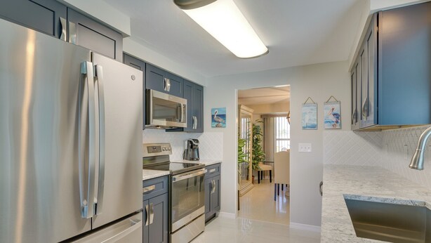 A modern kitchen with stainless steel appliances, a microwave, and a built-in oven. - Canalfront Home w/ Dock & Pool: 5 Mi to Ft Myers! (North Fort Myers)
