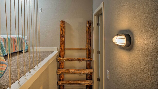 A wooden ladder against a wall with a light fixture above it. - Wooded Gilbertsville Hideaway on Kentucky Lake! (Gilbertsville)