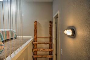 A wooden ladder against a wall with a light fixture above it. - Wooded Gilbertsville Hideaway on Kentucky Lake! (Gilbertsville)