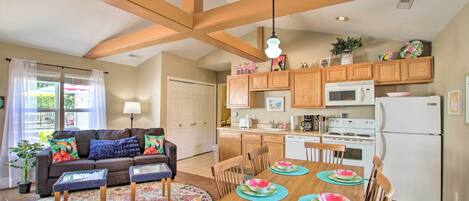 A modern kitchen with wooden cabinets, a white refrigerator, and a dining table set with placemats and plates.