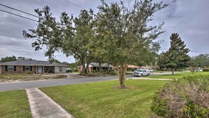 A residential street with houses, a sidewalk, and a grassy area. - Breezy Gulfport Getaway < 1 Mile to Beach + Casino (Gulfport)