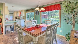 Comedor con una mesa de madera, cuatro sillas y un mantel a cuadros rojos.