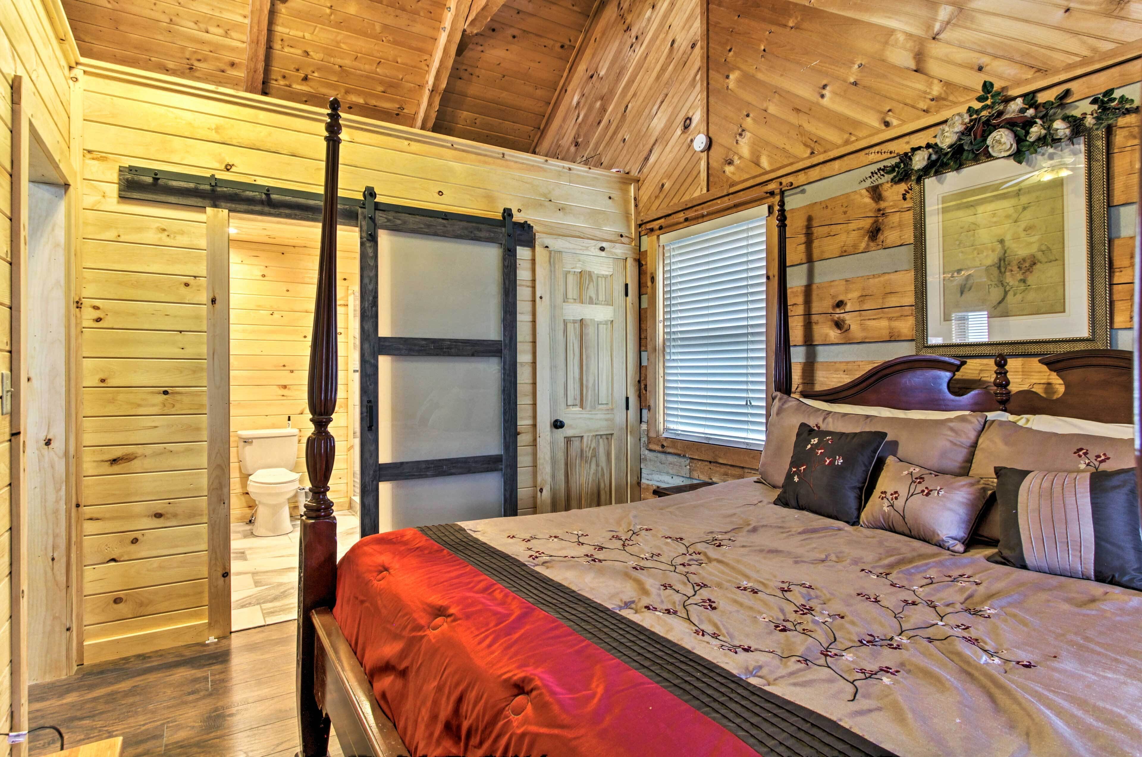 A wooden-paneled bedroom with a four-poster bed, a sliding door, and a framed picture above the bed.