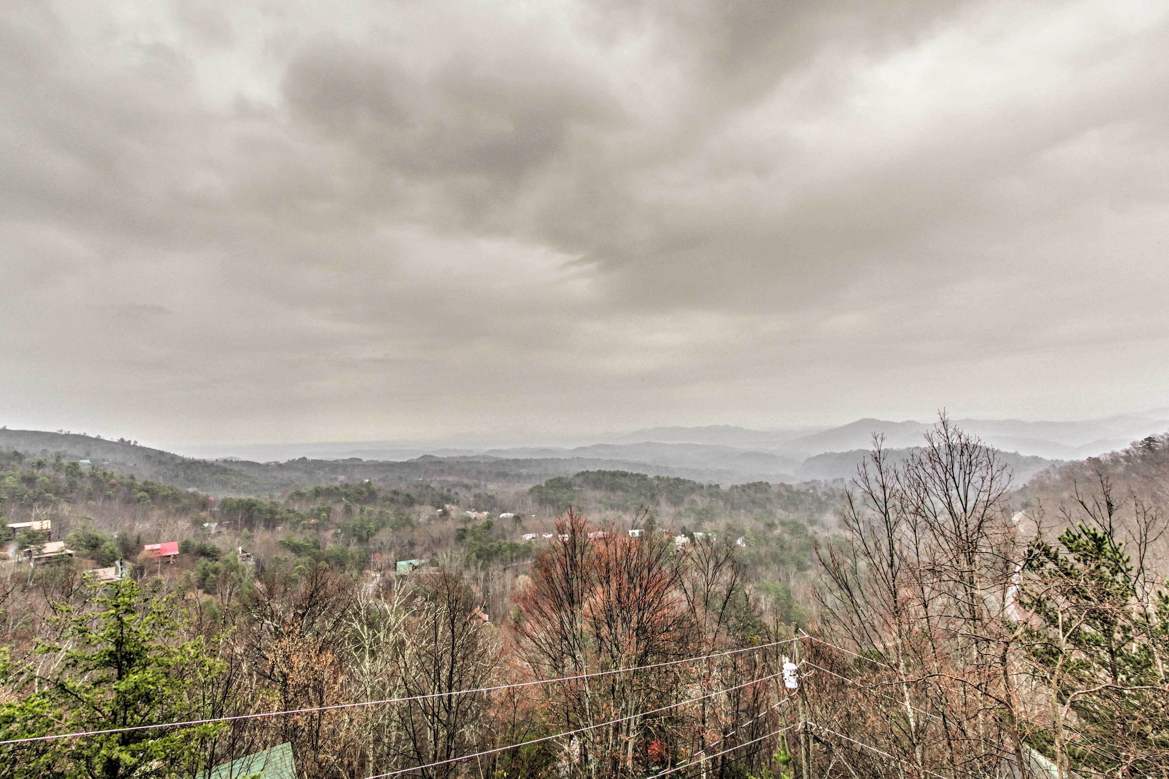 Panoramica di un paesaggio montuoso con case sparse e alberi.