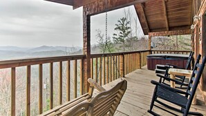 A wooden deck with a hot tub, a table, and chairs. - Sevierville Cabin w/ Private Hot Tub & Fireplace! (Sevierville)