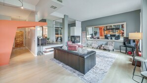 A spacious living area with a large sofa, a dining table, and a kitchen in the background. - Dtwn Cleveland Loft-style Condo: Walk to Stadiums! (Cleveland)