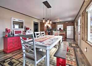 Una cocina con mesa, sillas y un armario rojo.