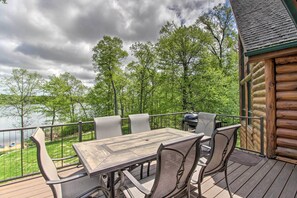 A wooden deck with a table and chairs, overlooking a lake and surrounded by trees. - Stunning Crosslake Cabin w/ Deck and Lake Views! (Crosslake)